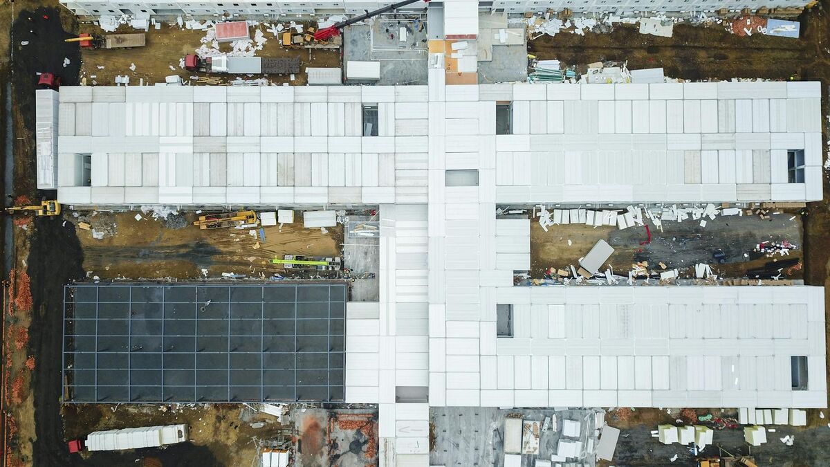 Drone aerial view of a large construction site with unfinished buildings and active development