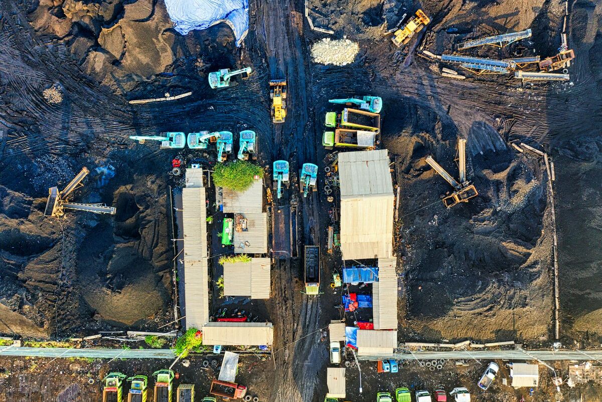 High-angle aerial drone view of a bustling construction site with machinery, trucks, and earthwork in progress