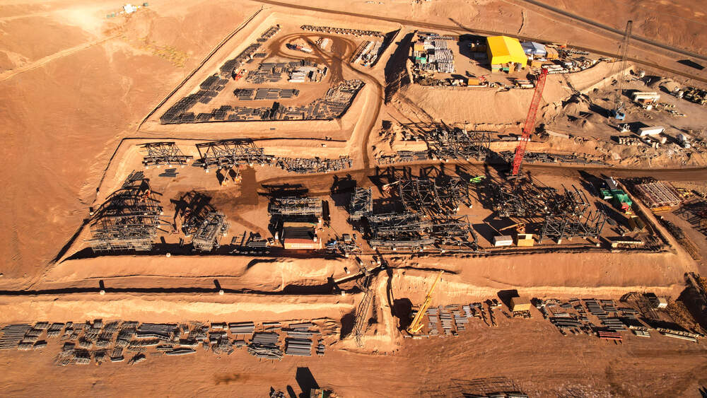 Aerial drone view of a large active construction site showing excavation and structural work