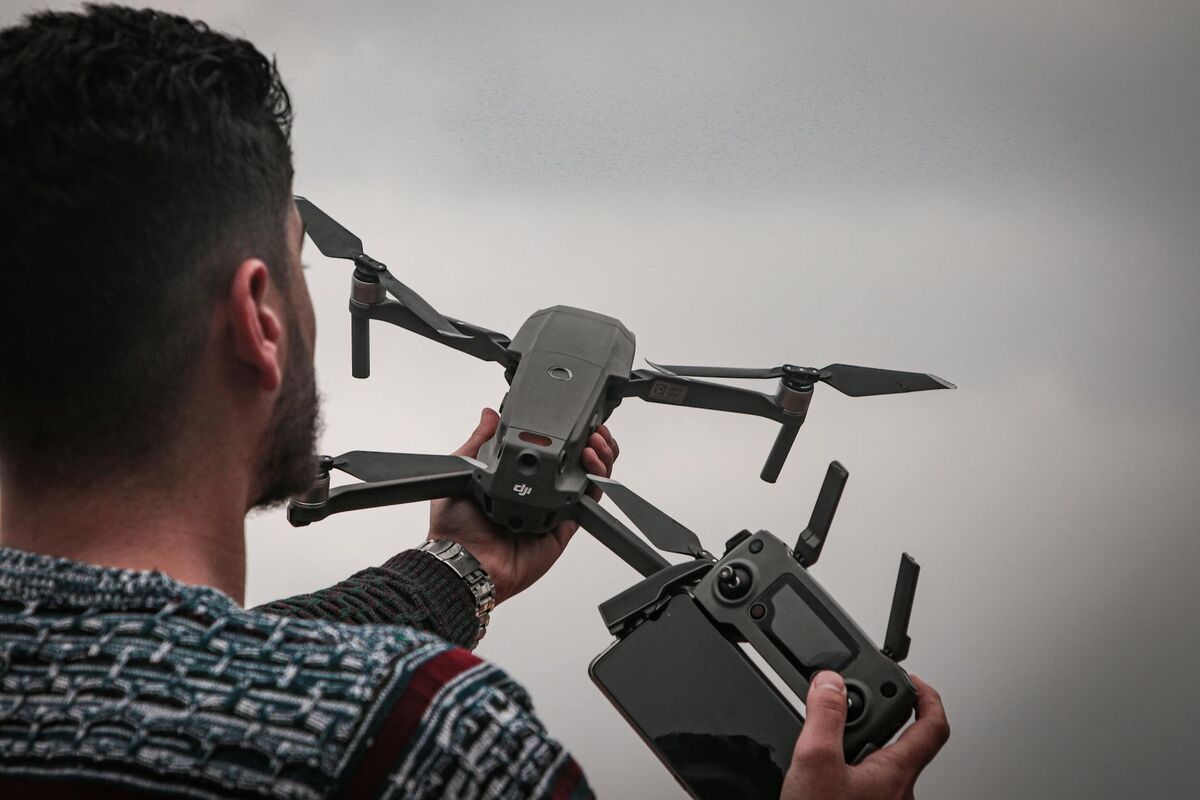 Man operating a drone with a remote controller outdoors