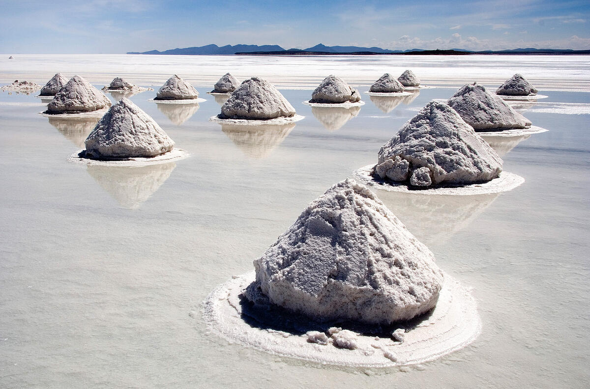Large salt stockpile mounds stored outdoors at a Bolivian salt flat depot