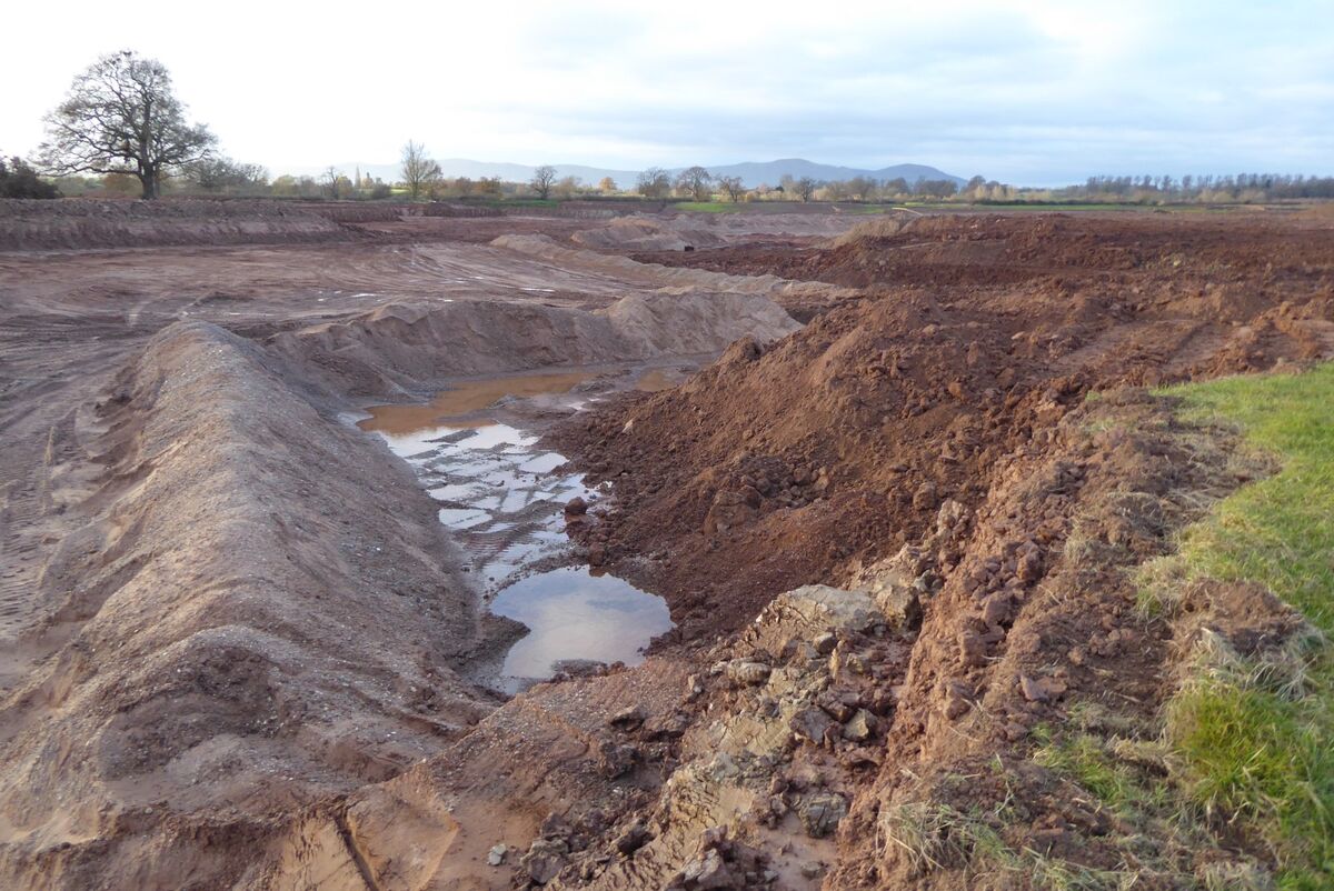 Gravel extraction pit showing aggregate mining operations and material stockpiles