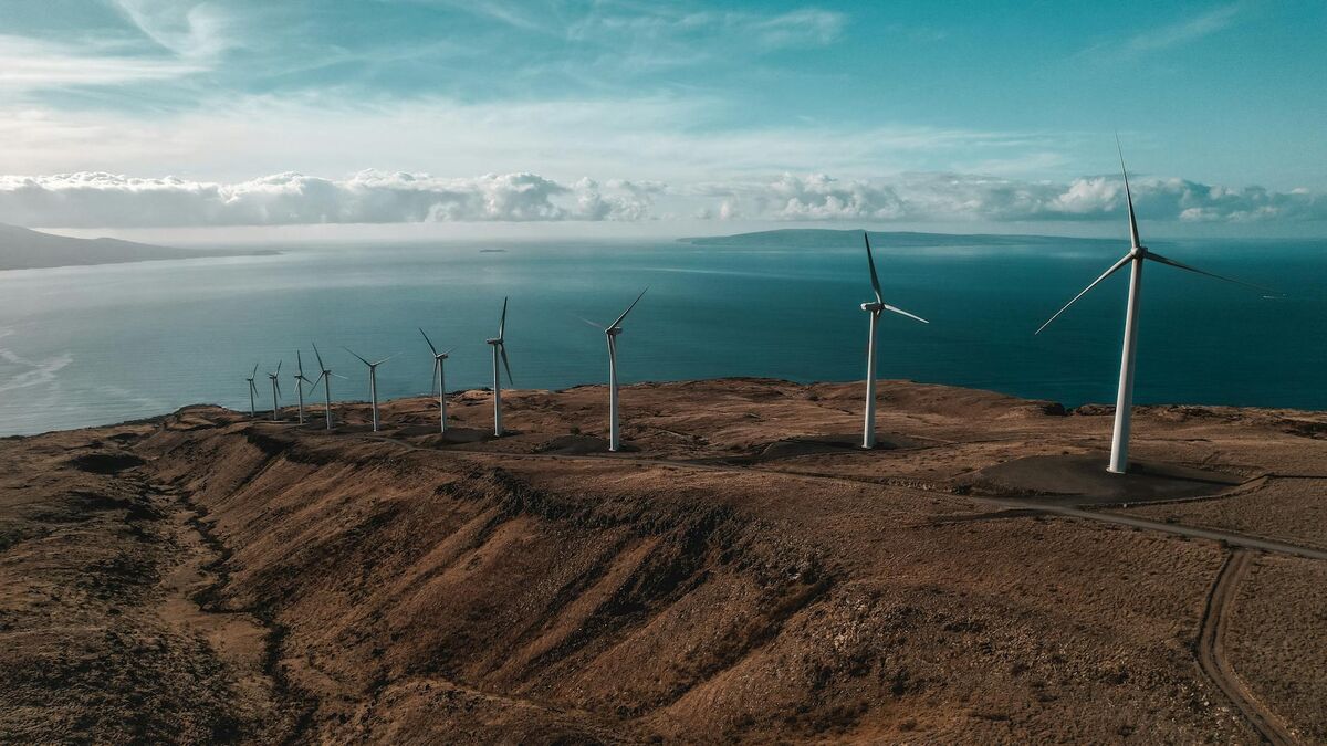 Aerial view of wind turbines from drone perspective showing full tower and blade span