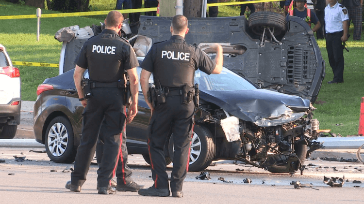 Police officers documenting crash scene using traditional methods